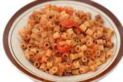 tasty appetizing classic ring pasta macaroni with tomato sauce and pieces, garlic, onion, spices, oil and black and green pepper, selective focus of an Italian recipe done the Egyptian way