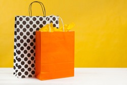 Arrangement of shopping bags on bright yellow background