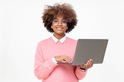 Studio portrait of smiling african american teen girl looking at camera, online course student holding laptop, isolated on gray background