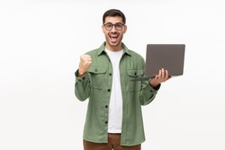 Screaming amazed winner holding laptop and celebrating success, isolated on gray background