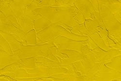 Background of yellow plastered wall close up. Mustard color backdrop.