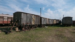 Old wooden train carriages abandoned by the side of the track