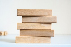 A pile of five wooden blocks on the soft white background.