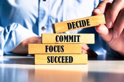 Motivational and inspirational quote Decide, commit, focus, succeed written on wooden blocks.