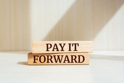 Wooden blocks with words 'Pay it forward'. Business concept