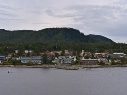 View of small remote village Bella Bella, part of Indian Reservation of Heiltsuk First Nation, on Campbell Island on the Lama Passage, British Columbia, Canada on cloudy day in autumn with forest.