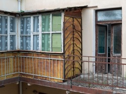 Exterior of aged glazed balcony. Loggia-type balcony of the old building. Concept of poor, grimy, decrepit housing