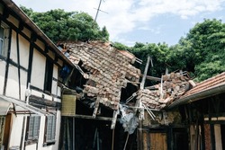 Damaged rooftop with multiple broken tiles after hurricane or earthquake