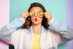 My favorite cookies. Pretty girl covering eyes with cookies. Bakery style chocolate chip cookie recipe. Cute girl having fun with cookies. Following a cooking recipe. Bakery shop.