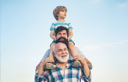 Men generation: grandfather father and grandson are hugging looking at camera and smiling. Fathers day concept. Generation concept. Weekend family play. Men in different ages