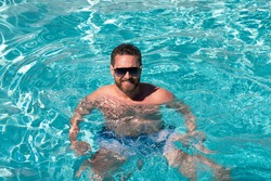 Pool spa resort. Summertime vacation at pool. Summer weekend. Handsome man in swimmingpool.