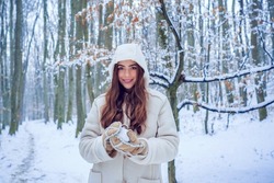 Winter woman fun. Girl playing with snow in park. Winter woman clothes. Winter woman snow.