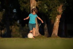 Soccer kid. Kids play football on outdoor stadium field. Little boy kicking ball. School football sports club. Training for sport children. Child soccer player in park.