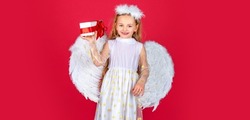 Angel children girl with white wings Cute baby child with angel wings. Angel kids with present gift, studio portrait. Little blonde angel with white wings holds gift. Valentines day, banner.