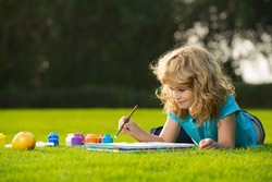 Schooler kids drawing in summer park, painting art. Little painter draw pictures outdoor. Happy child playing outside. Drawing summer theme. Imagination kids. Early childhood education.