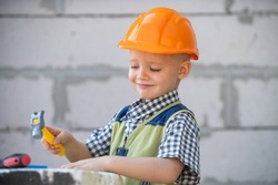 Portrait of little builder in hardhats with instruments for renovation on construction. Builder boy, carpenter kid with builder tools set. Repair home.