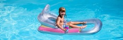 Kids happy summer. Summertime vacation. Child in pool. Boy swimming at swimmingpool. Funny kid on inflatable rubber mattress. Banner for header, copy space. Poster for web design.