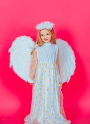 Angel child with white wings and angels halo, valentines day. Little prince greeting card. Angelic kids girl, isolated red studio background with copy space.