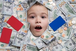 Kids head in money. Fun kid face on dollars money. Cash dollars banknotes, coins and credit card.