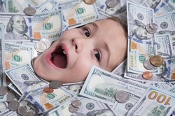 Head in money. Fun kid face on dollars money. Money banknotes, cash dollars bills, 100 American dollars banknotes.