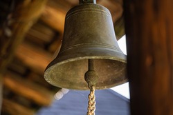 Bronze old metal bell hanged in house entrance outdoors