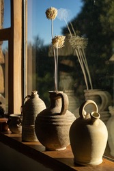 Three ceramic vase flagon front to big sunny window and its reflection