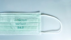  face mask with - Omicron variant ba.2 text on it. Covid-19 new variant - Omicron. Omicron variant of coronavirus. SARS-CoV-2 variant