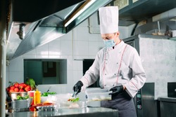 Food delivery in the restaurant. The chef prepares food in the restaurant and packs it in disposable dishes