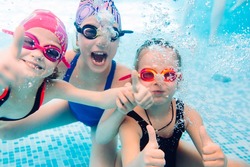 Underwater photo of young friends in swimming pool