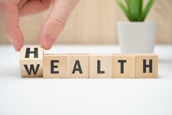 Concept health wealth on wooden block hold hand. Close up.