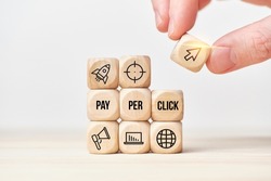 Concept Pay per click or PPC. Person stacks wooden cubes from text and icons