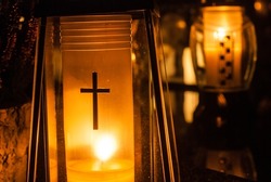 Yellow grave candles shining with light. Cemetery at night. Catholic Halloween tradition. All souls' day in Poland, Eastern Europe. Zaduszki.