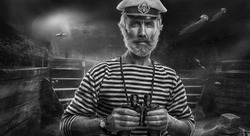 Elderly man sailor with binoculars on background of ocean