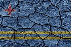 Aruba flag on a mud texture of dry crack on the ground