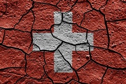 Switzerland flag on a mud texture of dry crack on the ground