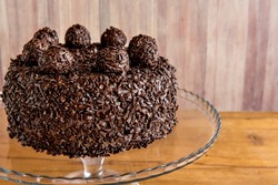 Delicious chocolate dessert, chocolate cake with brigadeiro on wooden table