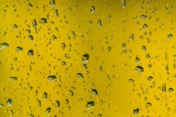 Rain drops on wndow glass, yellow background