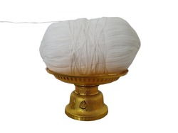 Holy thread. A long white thread wrapped in a coil and placed on a golden pedestal. It is an important sacred object in Buddhist and Brahmin ceremonies.