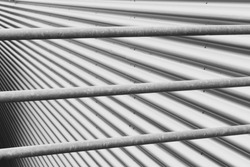 Abstract background of metal elements. Stainless steel tubes and wavy iron plate texture. Soft focus.