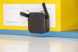 WiFi repeater in an electrical outlet on a yellow wall. An easy way to extend your wireless network at home