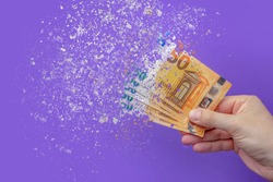 inflation euro . Inflation in Europe, hyper inflation. Banner with purple background. Fifty euro banknotes sprayed in the hand of a man on a purple background.