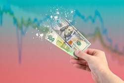 Inflation, hyperinflation, stagflation. One hundred dollar and one hundred euro banknotes splatter on the falling red graph. The concept of inflation and crisis in Europe and the United States.