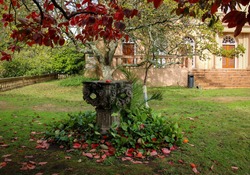 Sculpted stone surrounded by autumn foliage in the house garden