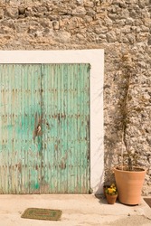 Cyan colored door of a small house in the salt town of Sa Canal on the island of Ibiza.