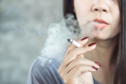 closeup Asian woman hand smoking cigarette ,unhealthy lifestyle concept 