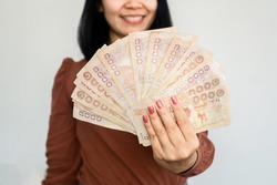 successful Asian woman hand showing Thai money banknotes ,investment and earning concept  