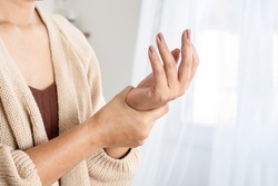 woman suffering from wrist pain, numbness, or Carpal tunnel syndrome hand holding her ache joint 