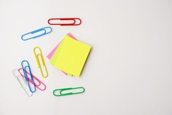 Selective focus of colorful sticky notes and paper clips. Flat lay, top view. Copy space. 