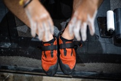 Climbing shoes and hands covered with white magnesium powder