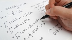 Handwriting to solve math formulas holding a computer pen. Math Formulas solves the test, practice, test or exam, background concept in math class.